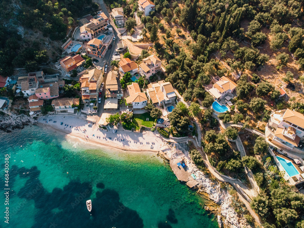 Beautiful beach with turquoise waters near authentic villas. Corfu, Greece. Top-down view.