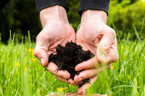 close-up of a man`s hands in the hands of an adult holding a dark moist soil. Ecology, landscaping, environmental protection. Selective focus. concept eco earth day