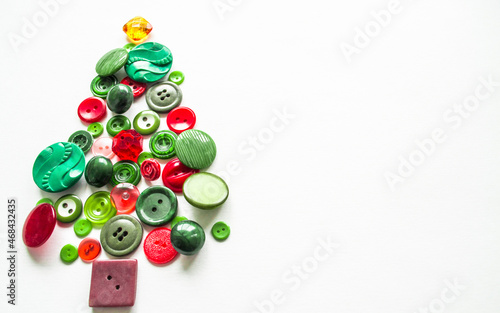 A Christmas tree made of buttons of green, red color. white background, copy space. Creative Christmas Concept