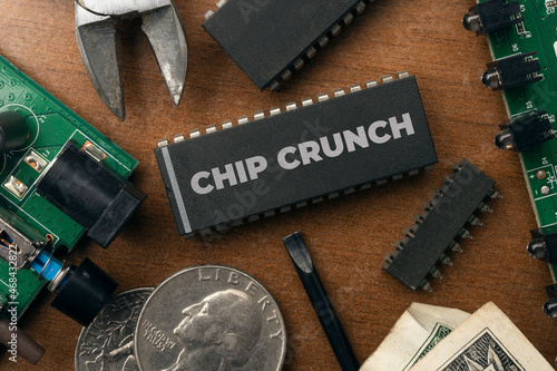 Chip crunch (semiconductor shortage) concept: some integrated circuit and electronic stuff on a wooden table. photo