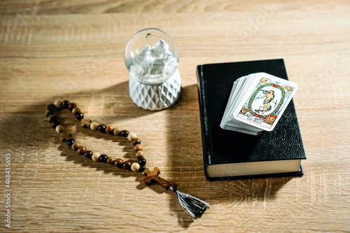 tarot cards, lenormand, divination cards, bible, rosary, book on a wooden table