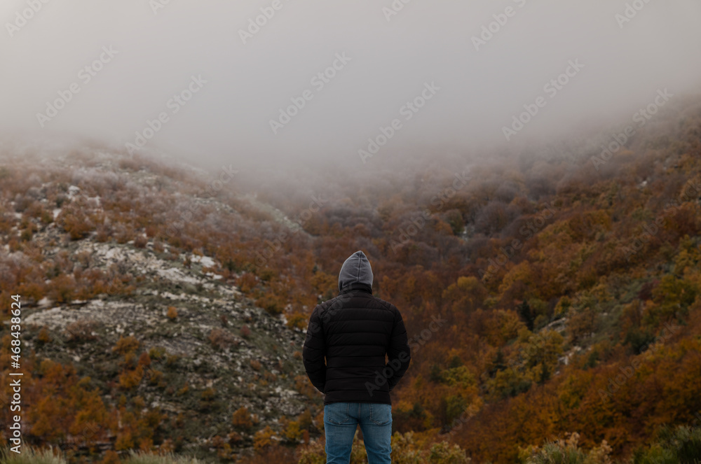 Portrait of adult man in black winter jacket against autumn color trees on mountain, in Tejera Negra, Cantalojas, Guadalajara, Spain Portrait of adult man in black winter jacket against autumn color trees on mountain, in Tejera Negra, Cantalojas, Guadalajara, Spain