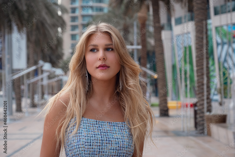 Young beautiful blonde woman walk in Dubai downtown. Enjoying travel in United Arabian Emirates. Vacation and sightseeing concept