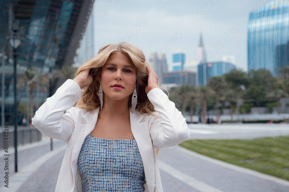 Young beautiful blonde woman enjoying time over walking in Dubai downtown. Enjoying travel in United Arabian Emirates. Vacation and sightseeing concept