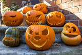 Viele Halloween Kürbisse mit bösen Gesichtern auf einer Treppe im Herbst