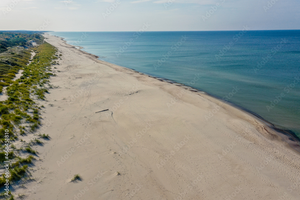 Obraz premium White sand beach. View to Baltic Sea Costline. Curonian Spit, Aerial view of the sea coast with waves. Travel and vacation concept.