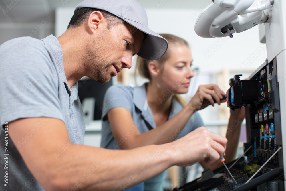 plumber and apprentice repairing washing machine