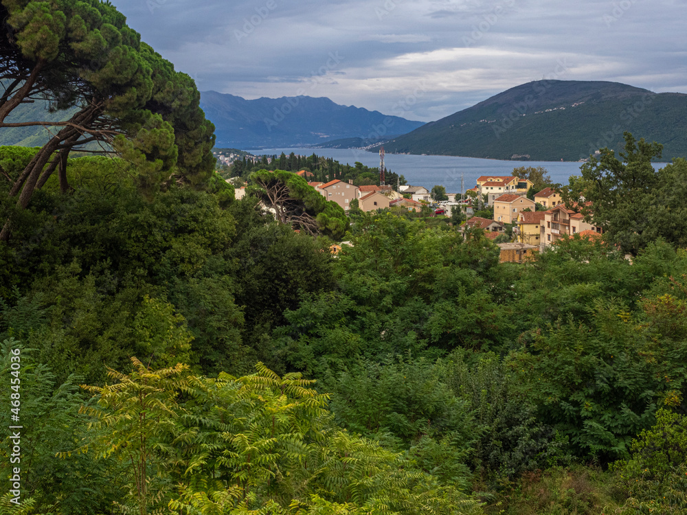 View looking down on town of Herceg Novi, Montenegro and the Adriatic Sea with homes and red tile roofs. 