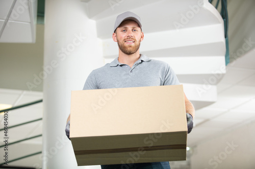 portrait of a smiling deliveryman in cap photo
