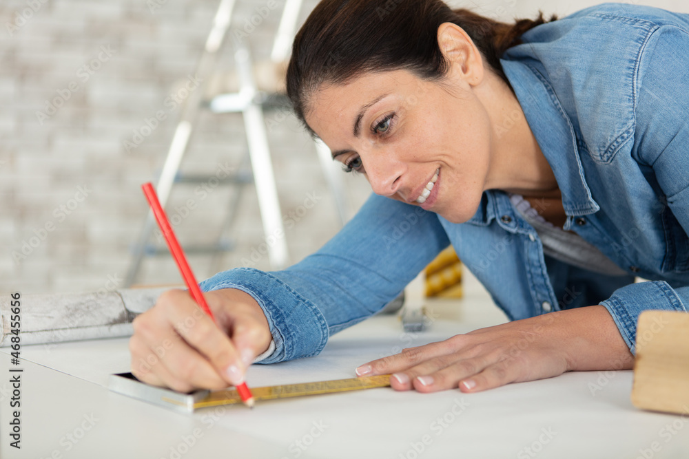 female redecorating using ruler to draw line female redecorating using ruler to draw line