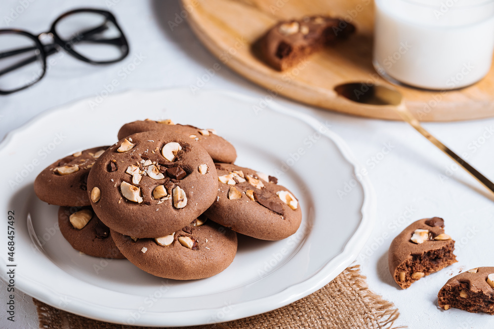 Close up of chocolate cookie with hazelnut and chocolate crumbs positioned on other cookies Close up of chocolate cookie with hazelnut and chocolate crumbs positioned on other cookies