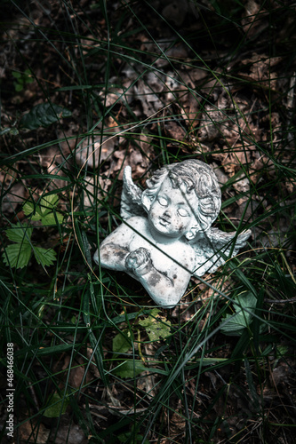 small stone angel lying in the grass