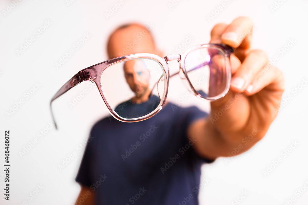 Myopia in mature men is corrected with glasses, a young man holds glasses in his hand. Myopia in mature men is corrected with glasses, a young man holds glasses in his hand.