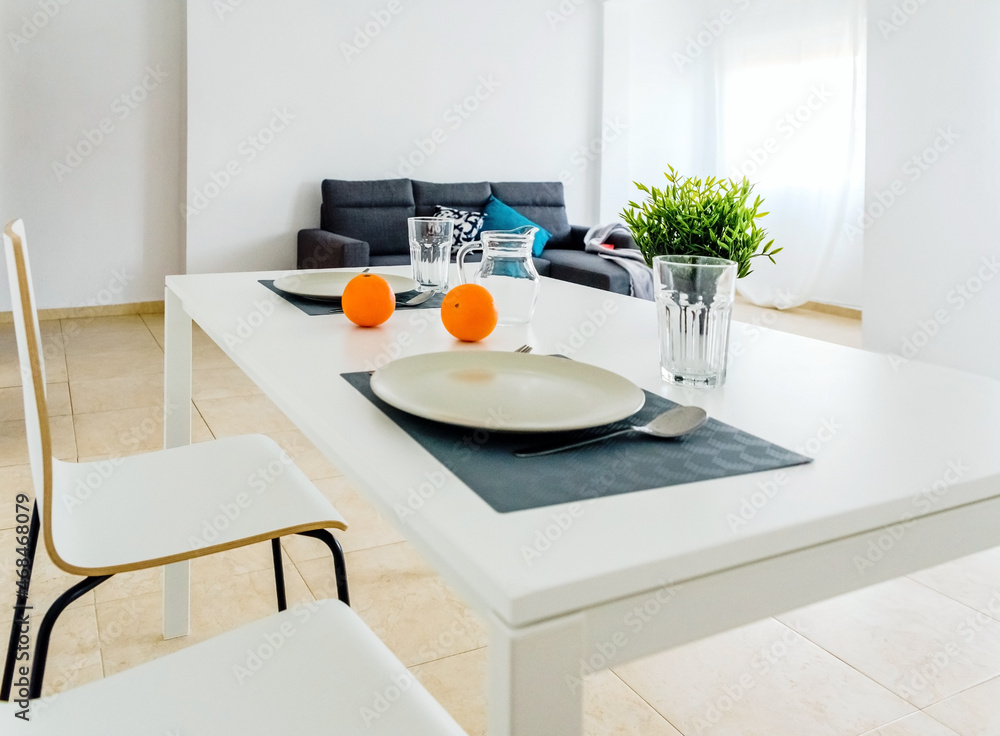 Simple white table in a very simple and bright minimalist living room.  Stock Photo | Adobe Stock