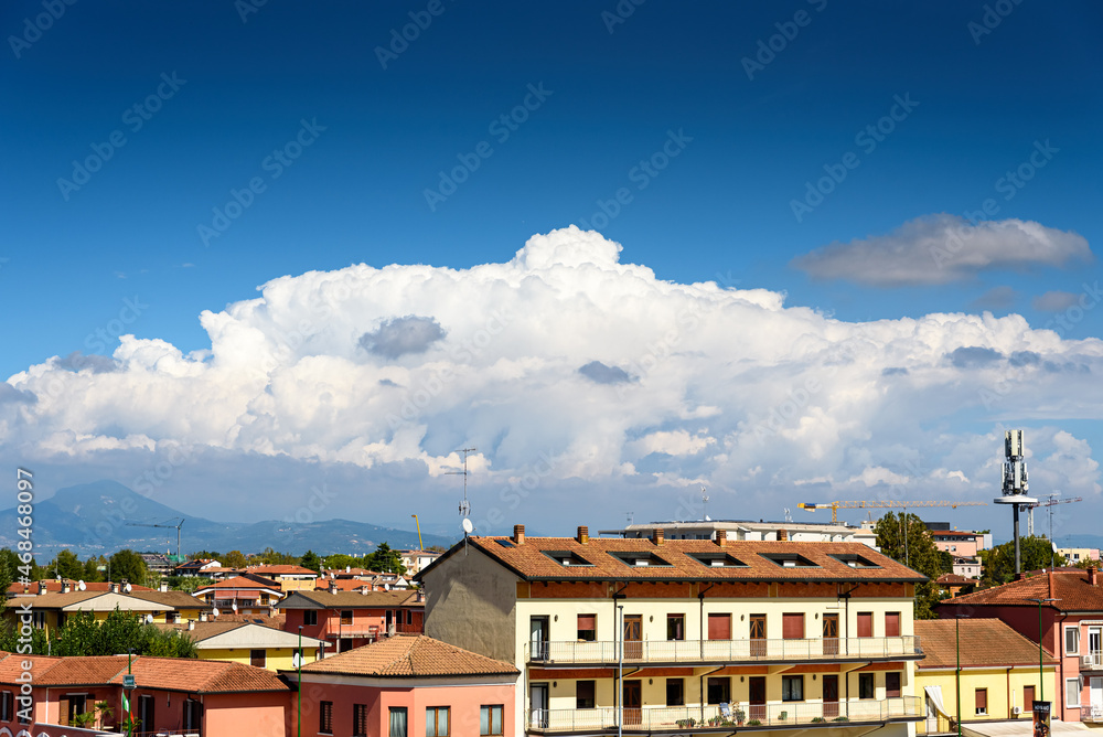 A cumulunimbus cloud of evolution descends from the mountains over a town.