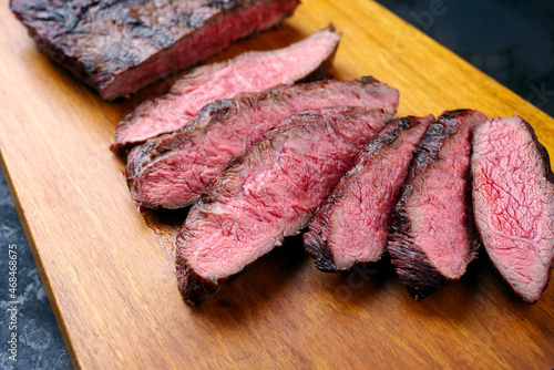 Traditional barbecue wagyu gourmet bavette steak served as close-up on a modern design wooden board photo