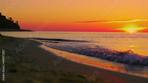 Panoramic landscape rock silhouette at orange sunrise morning. Ocean wave