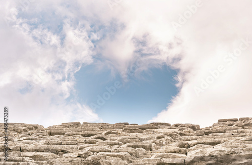 Closeup image of ancient amphitheatre ruins fragment in Turkey. Beautiful sky with clouds in the shape of heart. Copy space.