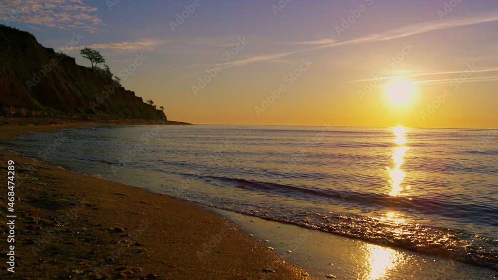 Mountain hill silhouette at evening coastline. Summer beach landscape sunset