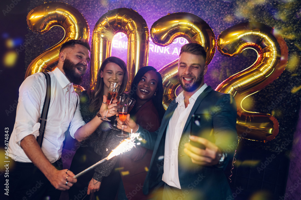 Fototapeta premium Happy group of friends celebrate New Year's Eve and taking selfie with a smartphone