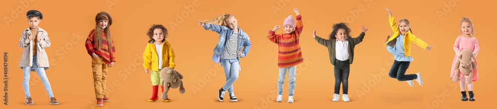 Group of stylish girls in autumn clothes on orange background - obrazy, fototapety, plakaty 