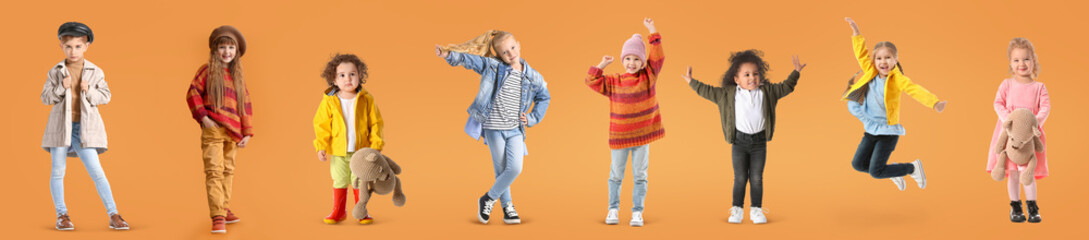 Group of stylish girls in autumn clothes on orange background