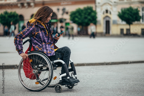 Woman with disability using a smartphone while out in the city