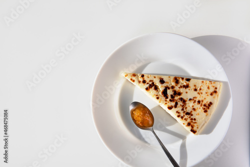 Obraz na plátně Traditional finnish squeaky cheese with cloudberry jam on the plate on white background