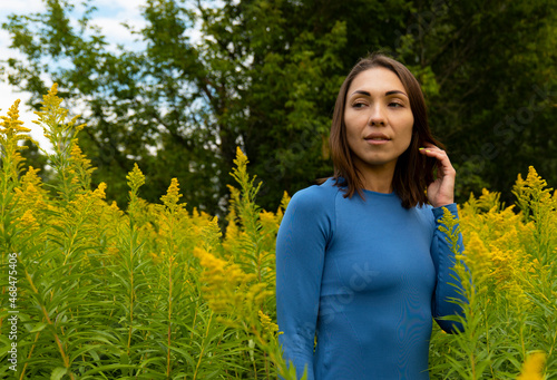 Young Asian woman in yellow colors outdoors. Portrait with a smile © YAROSLOVEPHOTOVIDEO