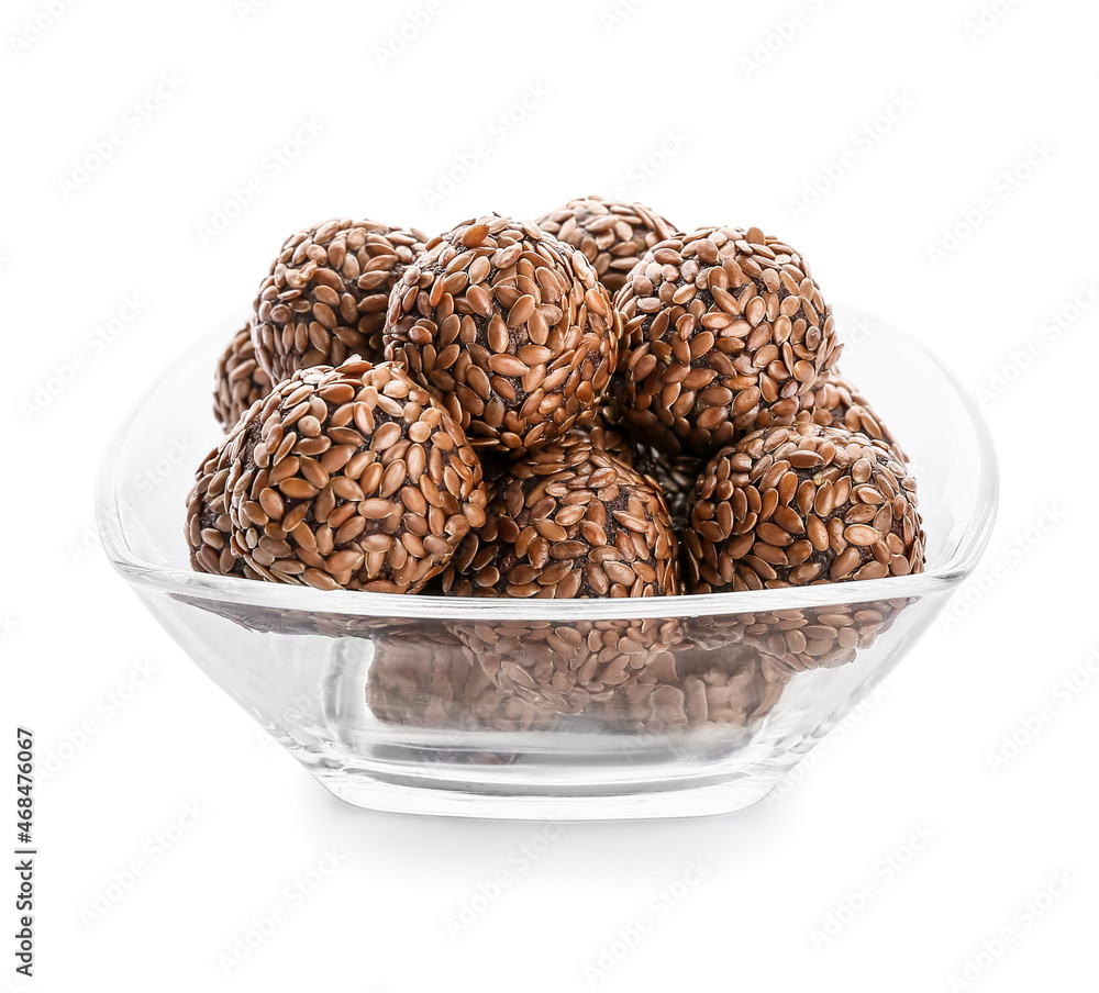 Bowl with tasty flax seed candies on white background Bowl with tasty flax seed candies on white background