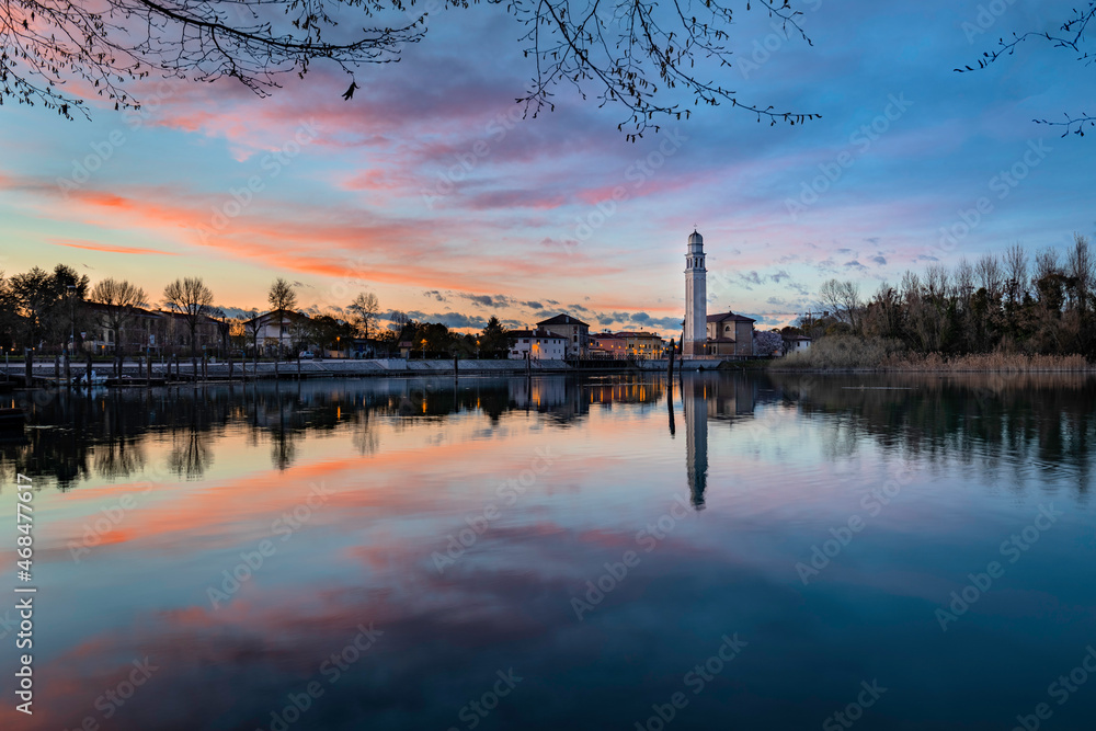 Chiesa di Casier al tramonto, riflessa nel fiume Sile lungo la restera, Treviso, Italia