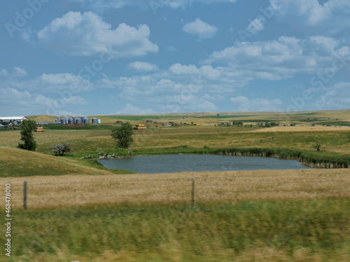 Small pond surrounded by greenery along Highway 44 in South Dakota  USA.
