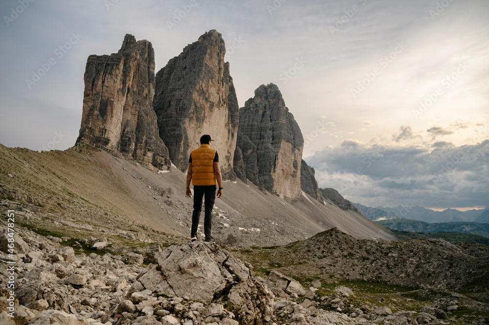 Three peaks of Tre Cime di Lavaredo and male person in foreground