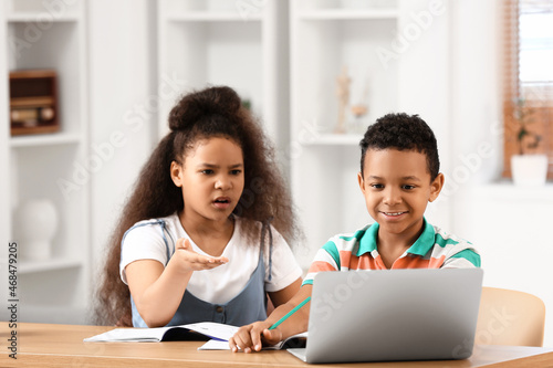 Little schoolchildren studying online at home