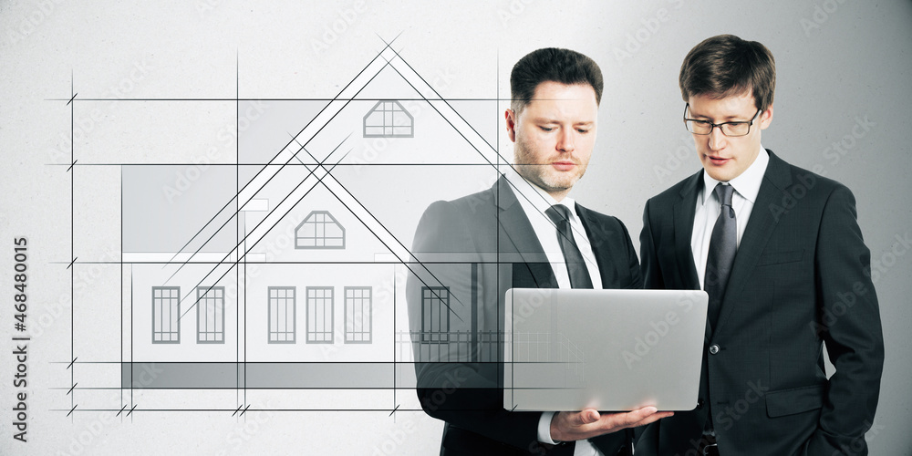 Attractive european businessmen using laptop with abstract drawing of creative house project blueprint on white background. Construction, teamwork, architecture, designer and plan concept. Attractive european businessmen using laptop with abstract drawing of creative house project blueprint on white background. Construction, teamwork, architecture, designer and plan concept.