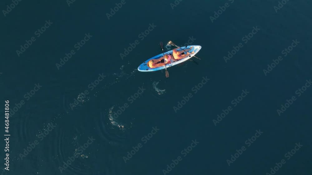Top view of a family kayaking in blue sea. Woman, man and children. Top view of a family kayaking in blue sea. Woman, man and children.