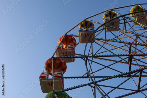 Ferris wheel spinning in an amusement park. Fairground ride. Colorful cabins of the ferris wheel spinning in an amusement park. Fairground ride. Close-up