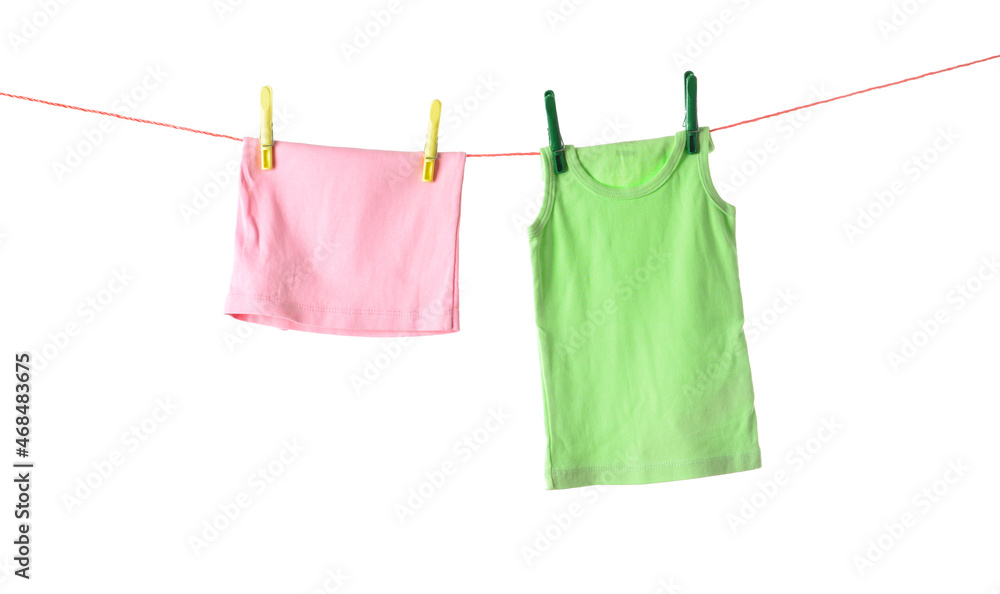 Child clothes hanging on rope with clothespins against white background