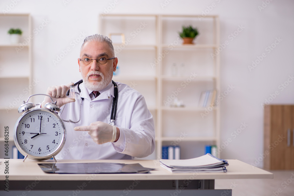 Old male doctor in time management concept Old male doctor in time management concept