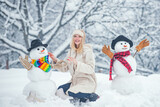 Winter girl. Happy young woman playing with a snowman on a snowy walk. Winter emotion. Young woman winter portrait. Christmas people.
