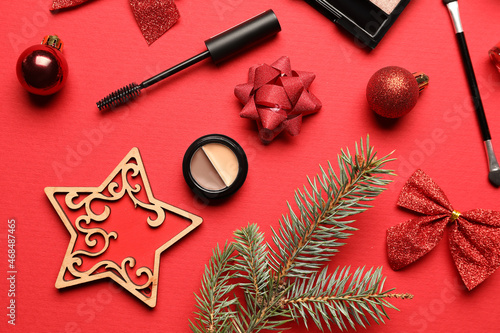 Fir tree branch, Christmas decor and makeup cosmetics on color background