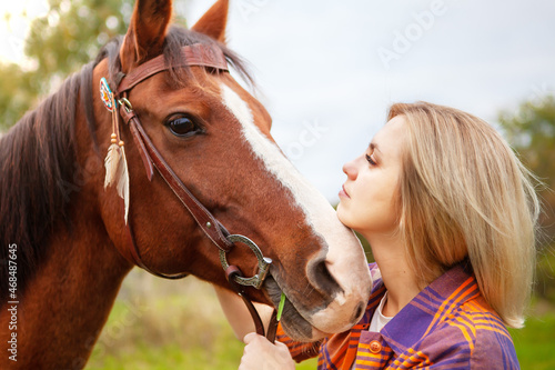 Beautiful young blond woman with a horse, portrait.