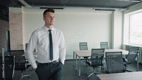 man walking in office looking on employee ass woman standing near workplace using laptop photo