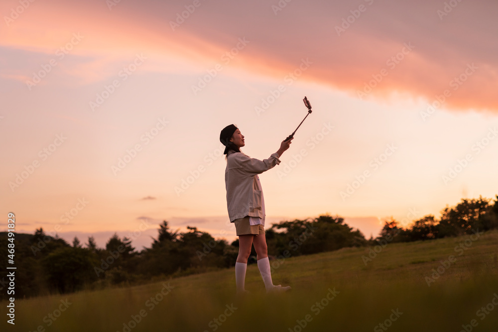 夕焼けの写真を撮る女性 夕焼けの写真を撮る女性