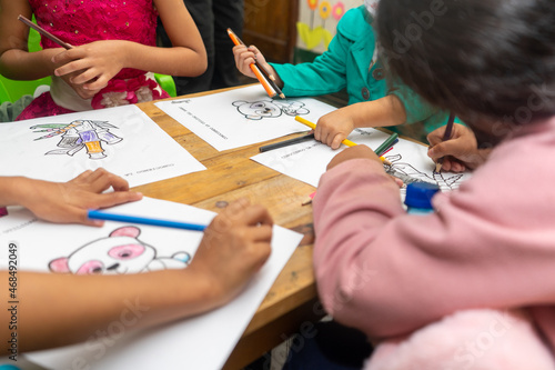 Fototapeta Naklejka Na Ścianę i Meble -  Hispanic kids drawing indoors using mask for coronavirus pandemic. Horizontal picture with copy space.