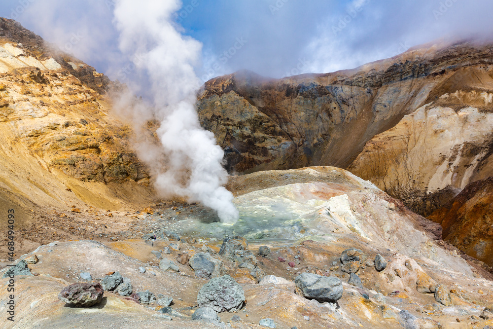 Scenery view of crater of active volcano, amazing volcanic landscape: hot spring and fumarole, lava field, gas-steam activity. Travel destinations for mountain climbing, active vacation and hiking.