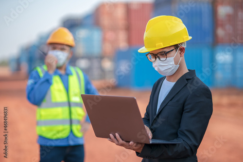 Engineers managers or businessmen work together with Foman controlling notebooks and radio Walkie-Talkie Wear a safety helmet and mask on face to prevent the spread of Coronavirus container background photo
