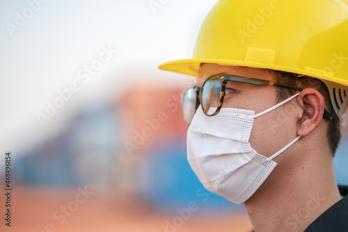 Closs up engineers managers or businessmen  Wear a safety helmet and mask on face to prevent the spread of Coronavirus covid-19 with container background.saffty and protection concept photo