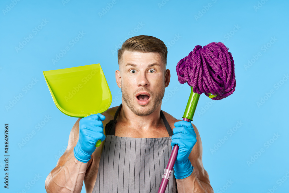 man in apron with mop posing muscular body housework