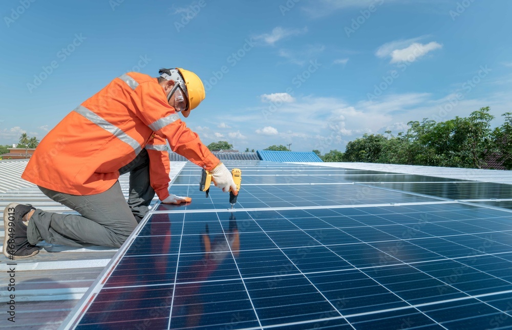 custom made wallpaper toronto digitalTechnician with drill installing solar panels on roof.Male in protective helmet installing solar photovoltaic panel using screwdriver mounting solar module on roof. Alternative energy ecological.